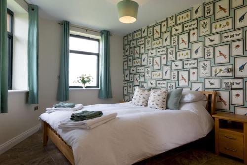 a bedroom with a bed and a wall of pictures at The Hexagon, wow what a location, views over the Essex marshes and sea in West Mersea