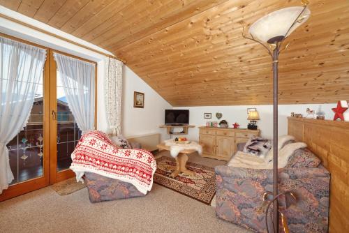 a living room with two chairs and a dog sitting on a couch at Alpen-Chalet-Sol-Alpium in Reit im Winkl