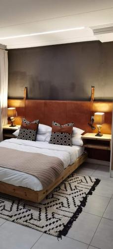 a bedroom with a large bed with two tables at The Blyde Apartment 1287 in Pretoria