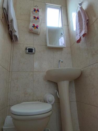 a small bathroom with a toilet and a sink at Loft em Cobertura in Rio de Janeiro