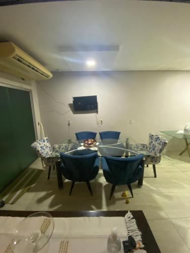 sala de estar con sillas, mesa y TV en Super Casa Piscina Com Cascata, en Manaus