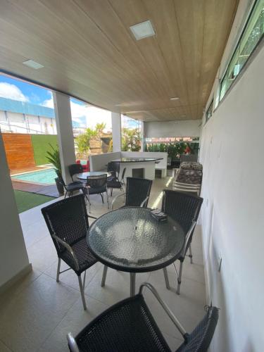 un patio con sillas, mesa, mesas y sillas en Super Casa Piscina Com Cascata en Manaos
