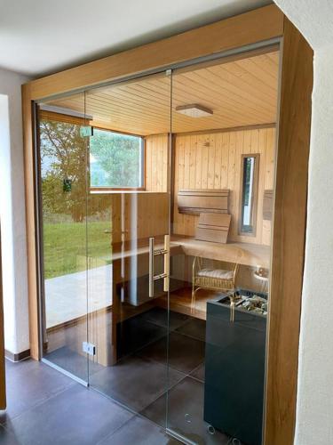 a room with a glass wall in a house at Ferienhaus mit privaten Schwimmteich und Sauna in Oed bei Gleisdorf