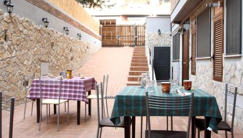 un patio con 2 tavoli, sedie e TV di Vatican Flat Cozy Court a Roma
