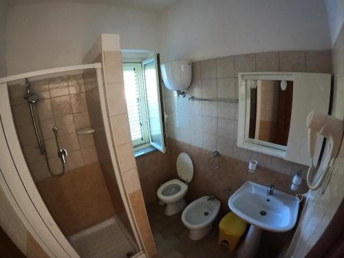 een badkamer met een douche, een toilet en een wastafel bij Agriturismo Seaview in Capo Vaticano