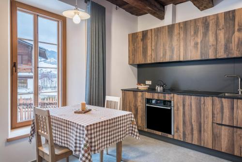a kitchen with a table with a table cloth on it at Alpin Chalet Samer Apt Berghütte in Sarntal