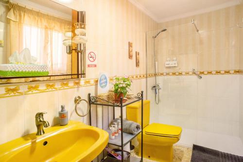 baño con lavabo amarillo y aseo en Casa Juana, en Agua de Fontanales