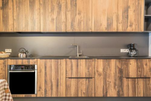 a kitchen with wooden cabinets and a sink at Alpin Chalet Samer Apt Berghütte in Sarntal