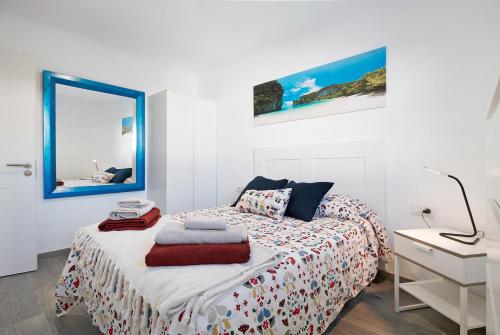 een slaapkamer met een bed, een bureau en een spiegel bij Casa Timanfaya in Playa Blanca