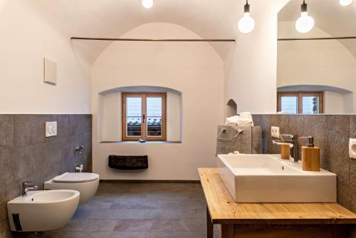 a bathroom with a white sink and a toilet at Alpin Chalet Samer Apt Bauernstube in Sarntal