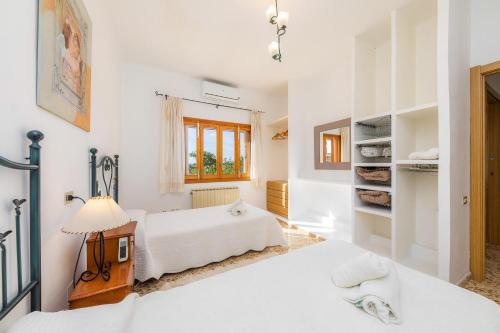 a bedroom with two beds and a lamp at Son Valenti in Sa Pobla