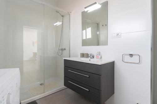 een witte badkamer met een wastafel en een douche bij Steps from Puerto Marina in Benalmádena