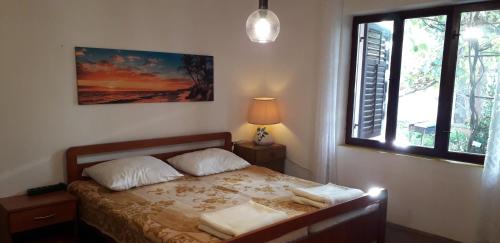 a bedroom with a bed with two pillows and a window at Apartment Len Slovaci in Zadar