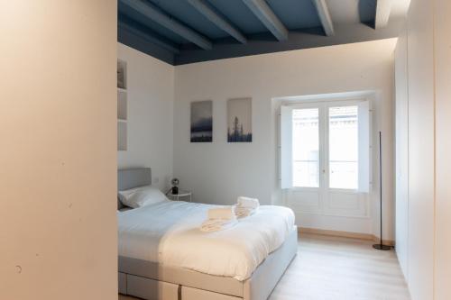 a white bedroom with a bed and a window at Easylife - Accogliente e moderno bilocale in zona Navigli in Milan