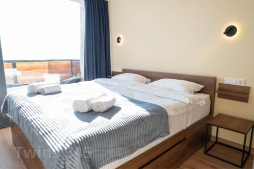 a bedroom with a bed with towels on it at Valley & Mountain View, Twins, with Hot Water in Gudauri