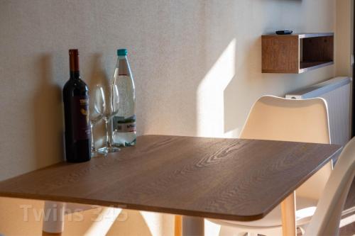 a wooden table with two bottles and two glasses at Valley & Mountain View, Twins, with Hot Water in Gudauri