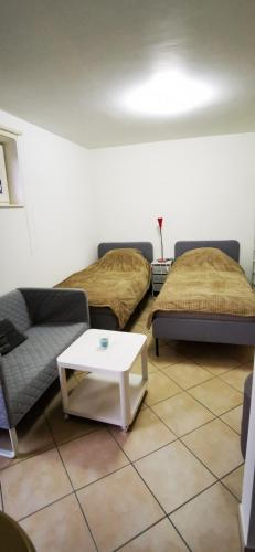 een woonkamer met 2 bedden en een salontafel bij Studio équipé Brussels in Sint-Pieters-Leeuw
