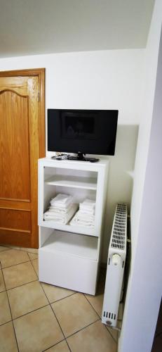 a white cabinet with a tv on top of it at Studio équipé Brussels in Sint-Pieters-Leeuw