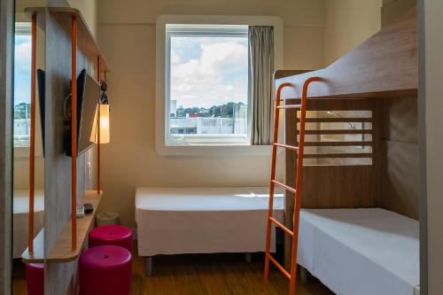 a small room with bunk beds and a window at ibis budget Foz do Iguaçu in Foz do Iguaçu