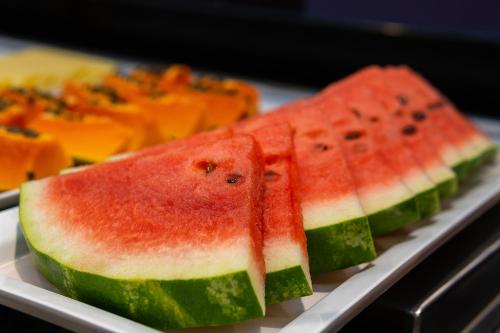 two slices of watermelon on a plate with other fruits at ibis budget Foz do Iguaçu in Foz do Iguaçu