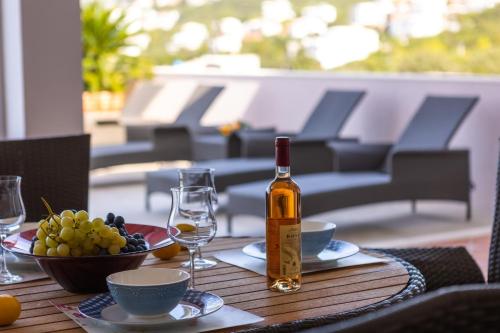 a bottle of wine on a table with a bowl of fruit at Villa Maren in Utjeha