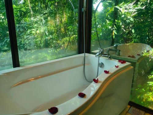 a bath tub in a bathroom with a window at Villa Sri Kampung in Kuah