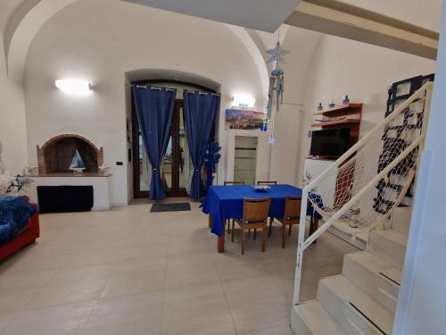 a dining room with a blue table and chairs at Polignano a Mare: sulla piazza di Domenico Modugno in Polignano a Mare