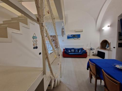 a dining room with a blue table and a couch at Polignano a Mare: sulla piazza di Domenico Modugno in Polignano a Mare