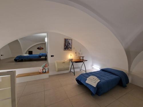 a bedroom with a blue bed in a white room at Polignano a Mare: sulla piazza di Domenico Modugno in Polignano a Mare
