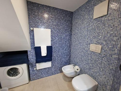 a bathroom with a toilet and a washing machine at Polignano a Mare: sulla piazza di Domenico Modugno in Polignano a Mare