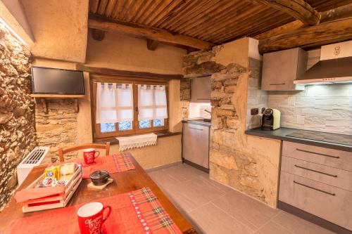 eine kleine Küche mit einem Tisch und einer Arbeitsplatte in der Unterkunft La Mason dla Grà in Frassinetto