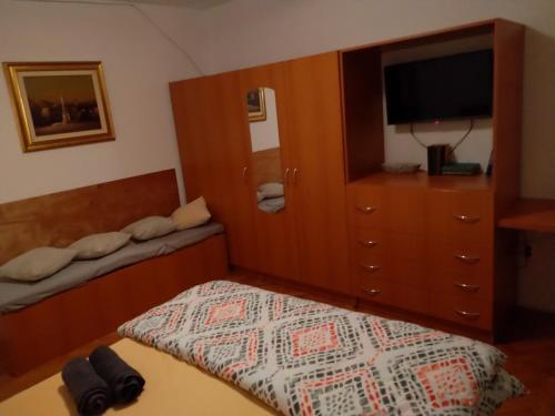um quarto com uma cama e uma cómoda com uma televisão em Apartman Gašparić Ivanka - prvi do bolnice em Krapinske Toplice