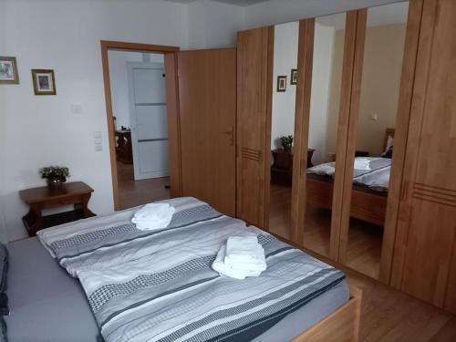 1 dormitorio con 1 cama grande y toallas. en Apartment E2 - Gut ausgestattete 3-Zimmerwohnung 64 qm, für 1-3 Personen 1 DZ 1EZ, en Grafenwöhr