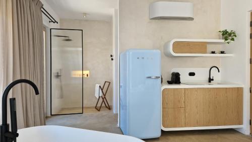 uma cozinha com um frigorífico azul num quarto em Ivy's Natural Resort em Arnados
