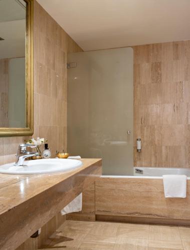 a bathroom with a sink and a bath tub at Grand Hôtel Bristol in Colmar