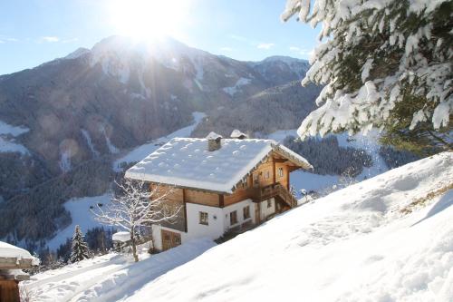 a house on top of a snow covered mountain at Ferienhaus Rauchegg - Bergblick in San Pancrazio dʼUltimo