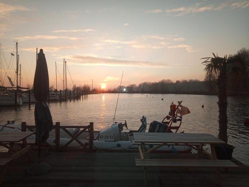 a boat is docked in the water at sunset at Kaap Hoorn Club Bed en Breakfast in Hoorn