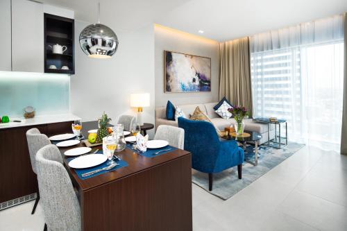 a living room with a couch and a table and chairs at Somerset Downtown Al Khobar in Al Khobar