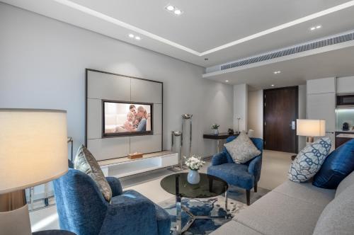 a living room with blue chairs and a couch at Somerset Downtown Al Khobar in Al Khobar