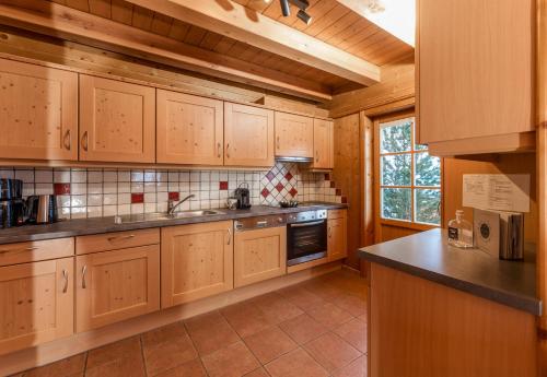 a kitchen with wooden cabinets and a counter top at Almwelt Austria in Schladming