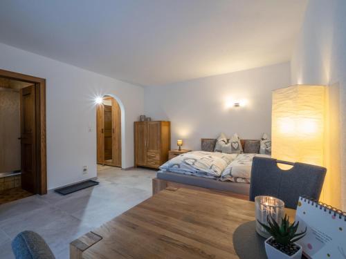 a bedroom with a bed and a table in a room at Appartement Alpenlöwe in Kirchberg in Tirol