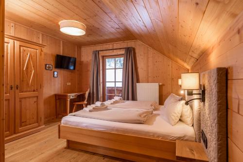a bedroom with a bed in a wooden room at Almwelt Austria in Schladming