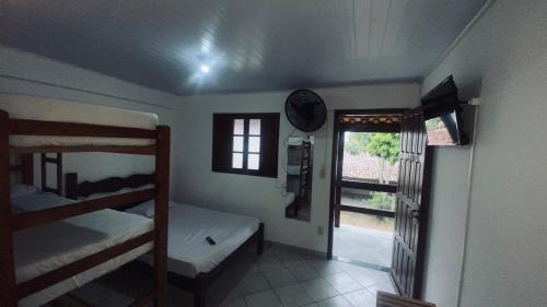 a room with two bunk beds and a window at Quitinete família standard 202 in Cabo Frio