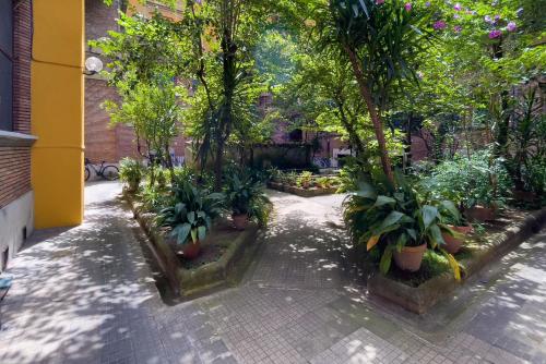 une cour avec des arbres et des plantes dans un bâtiment dans l'établissement Piazza San Pietro Suite, à Rome
