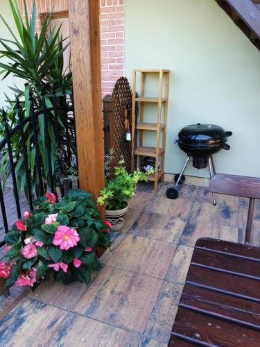 a patio with flowers and a grill and a table at Slunečnice - Ubytování v soukromí na Třeboňsku in Třeboň