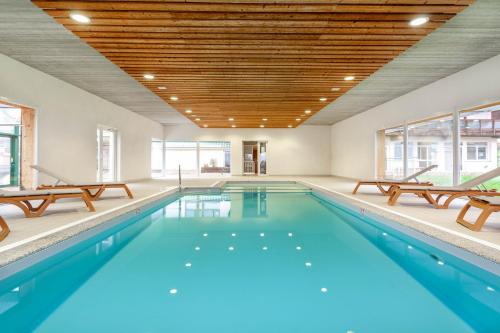 an indoor swimming pool with two chairs and a swimming poolvisor at Village Vacances Cap France La Bolle in Saint Die