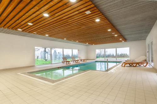 a large swimming pool in a large room with a ceiling at Village Vacances Cap France La Bolle in Saint Die