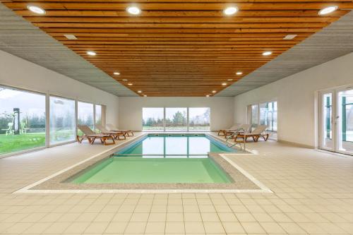 a swimming pool in a room with tables and chairs at Village Vacances Cap France La Bolle in Saint Die