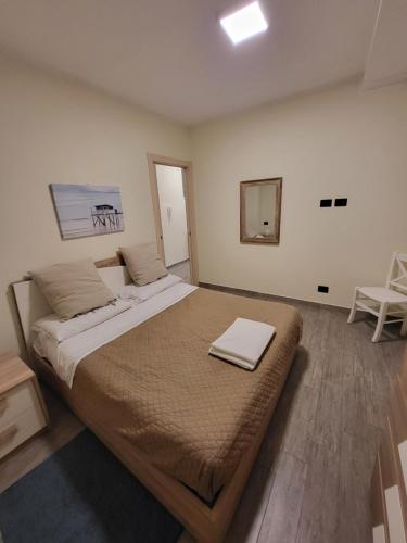 a bedroom with a large bed and a chair at Puppo Apartments in Corniglia