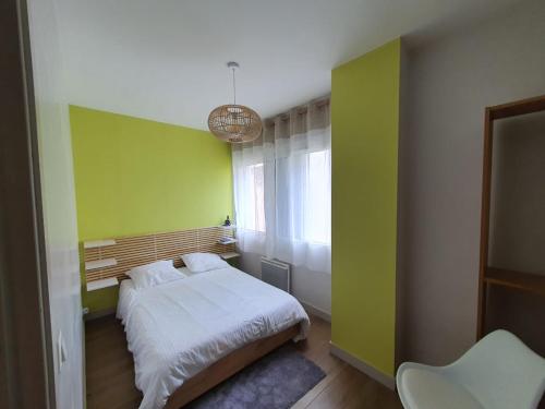 - une chambre avec des murs verts et blancs et un lit dans l'établissement MISSIAMINAGE, à La Rochelle
